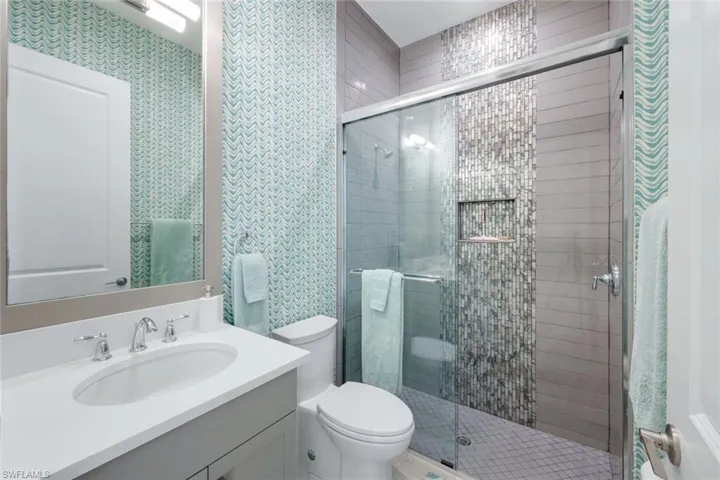 En suite Bath to bedroom 2 features mini shower tiles and designer wallcovering