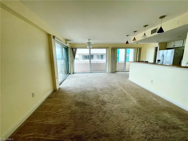 Unfurnished living room featuring ceiling fan and carpet
