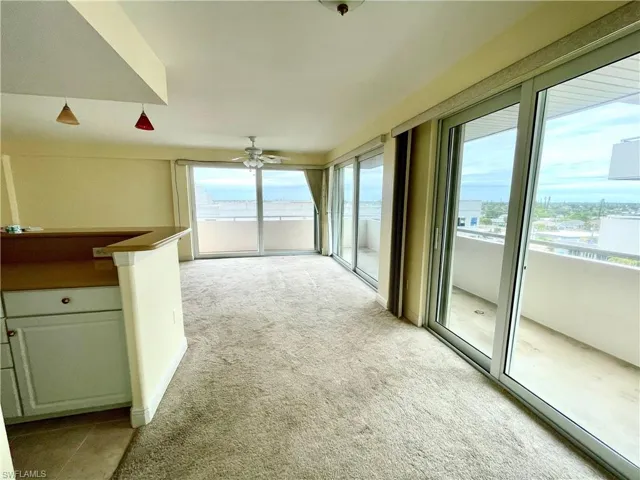 Unfurnished living room featuring light carpet and ceiling fan