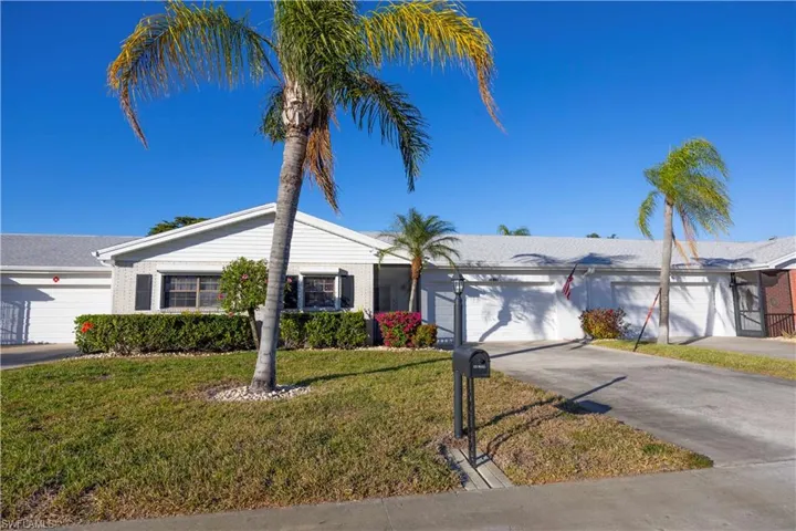 Single story home featuring an attached garage, driveway, a front yard, and brick siding