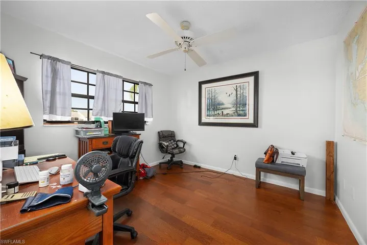 Office with dark wood finished floors and ceiling fan