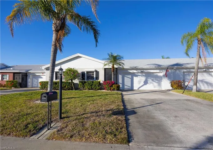 Single story home with concrete driveway, a front lawn, and an attached garage