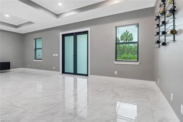 Empty room with light tile patterned flooring and a tray ceiling