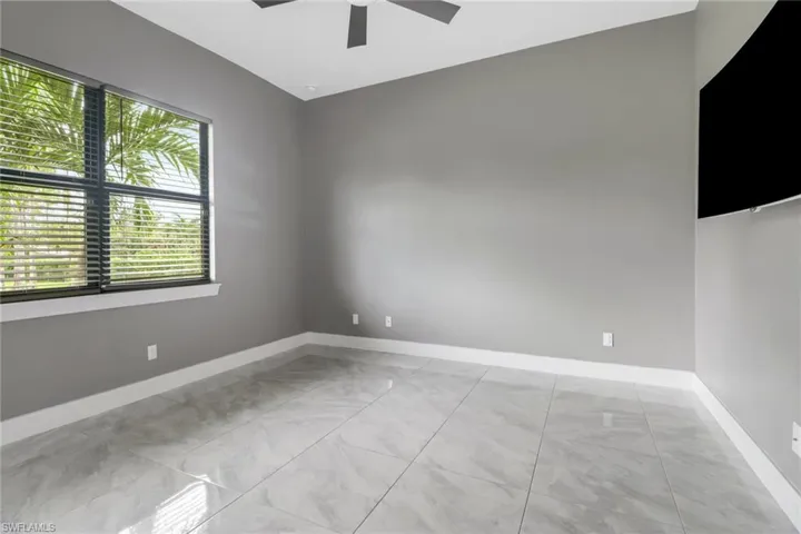Spare room featuring ceiling fan and light tile patterned floors