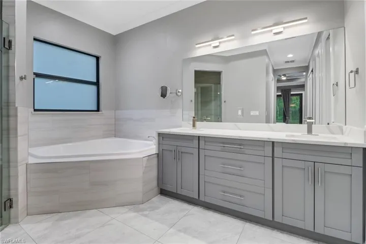 Bathroom with tile patterned floors, independent shower and bath, and vanity