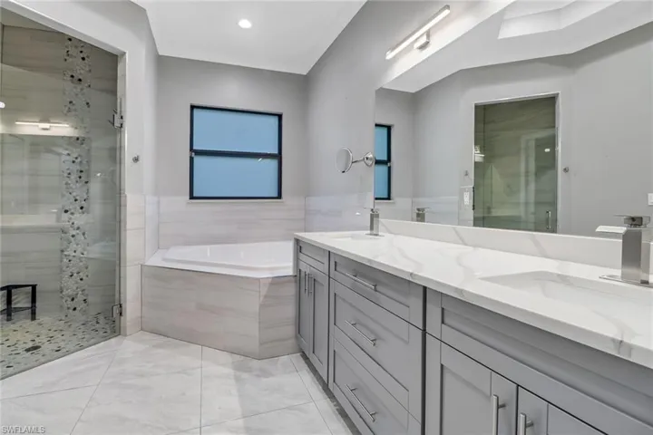 Bathroom with tile patterned floors, independent shower and bath, and vanity