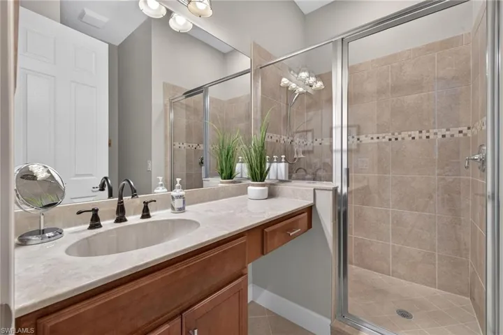 Vanity with integrated sink, bronze-finish faucet, and expansive mirror