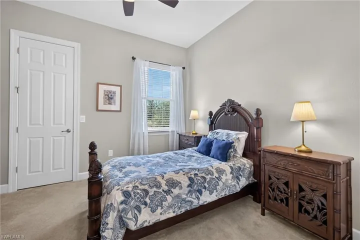 Vaulted ceiling, ceiling fan, neutral wall color, window with blinds, panel door