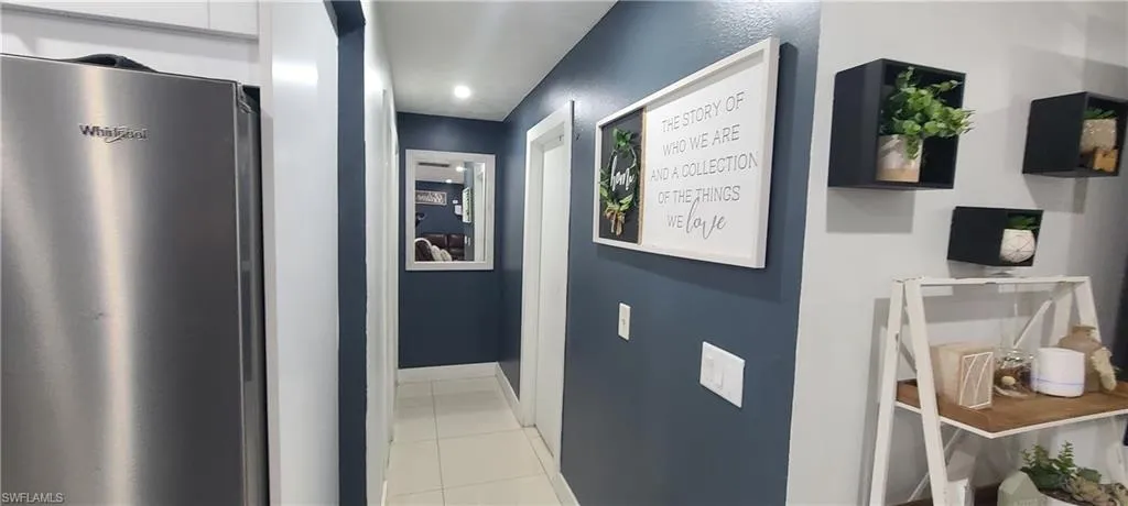 Hall featuring baseboards and light tile patterned floors