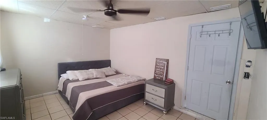 Bedroom featuring a paneled ceiling, ceiling fan, and light tile patterned floors