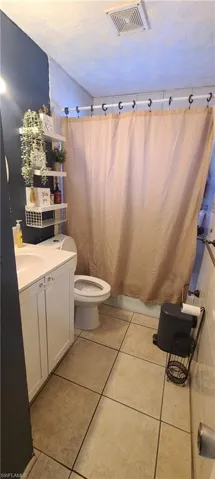 Full bathroom featuring vanity, a textured ceiling, and light tile patterned floors