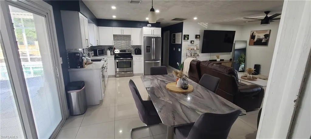 Dining area featuring ceiling fan, light tile patterned flooring, and recessed lighting