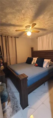 Bedroom featuring a textured ceiling and ceiling fan