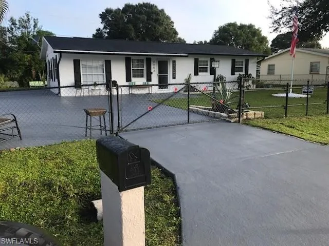 Single story home with a gate, a fenced front yard, and concrete driveway