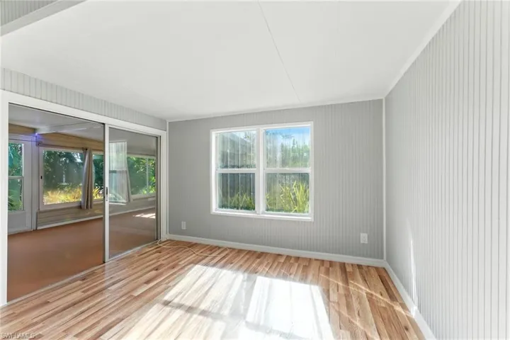 Empty room featuring wood finished floors and ornamental molding