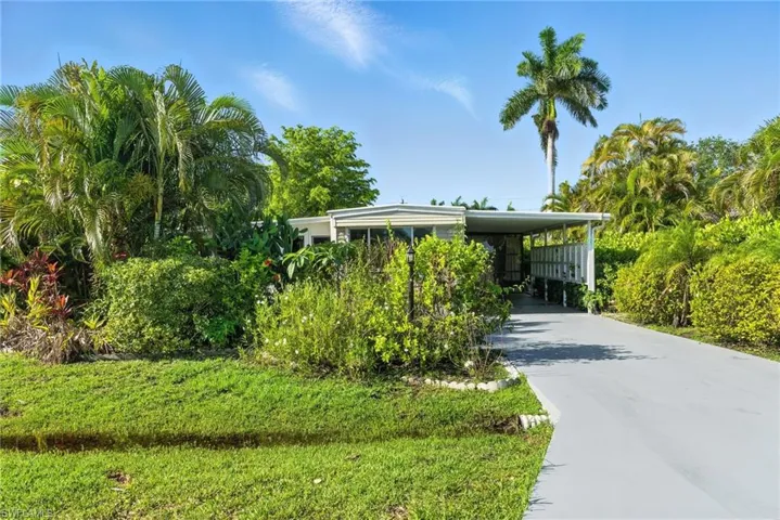 View of front of property featuring concrete driveway and an attached carport