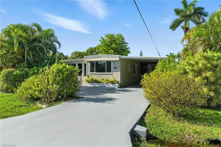 Manufactured / mobile home featuring driveway and an attached carport