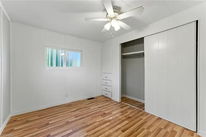 Unfurnished bedroom featuring light wood-style floors, a closet, and ceiling fan