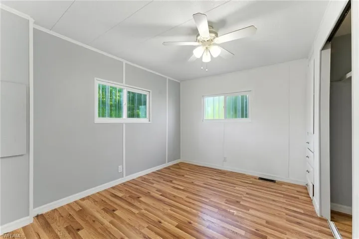 Unfurnished bedroom with light wood finished floors, ornamental molding, and a ceiling fan