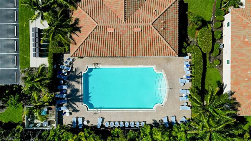 Rectangular swimming pool with integrated steps, surrounded by a light-toned paved deck