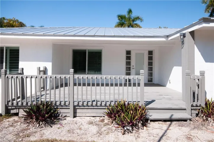 Property entrance with stucco siding and a deck