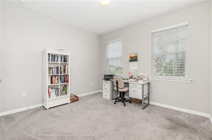 Office with baseboards and light colored carpet