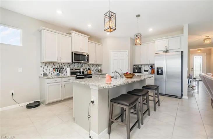 Kitchen with plenty of natural light, tasteful backsplash, appliances with stainless steel finishes, a kitchen breakfast bar, and recessed lighting
