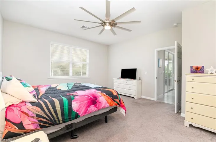 Bedroom with light carpet and a ceiling fan