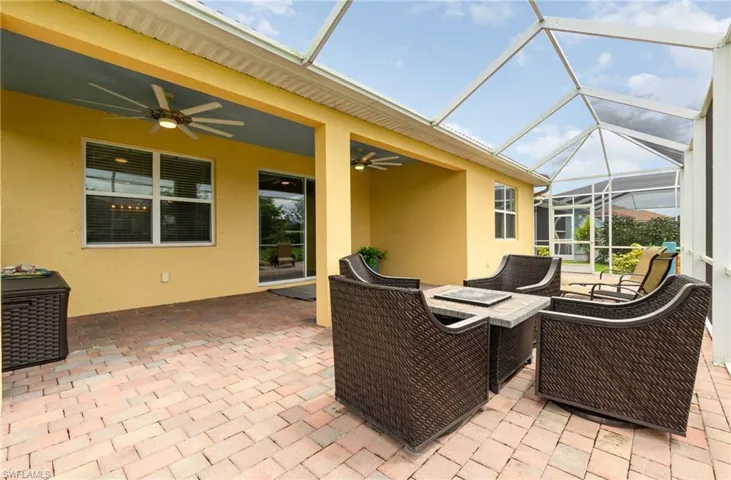View of patio featuring a sunroom, ceiling fan, a lanai, and a fire pit