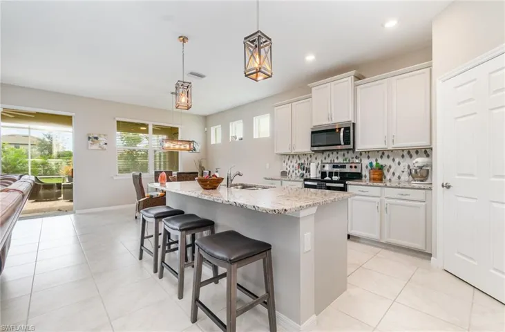 Kitchen with tasteful backsplash, light tile patterned floors, pendant lighting, a breakfast bar, and recessed lighting