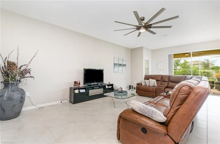 Living area featuring light tile patterned flooring and ceiling fan