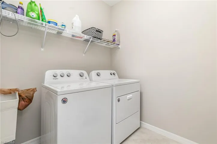 Laundry room featuring independent washer and dryer and light tile patterned floors