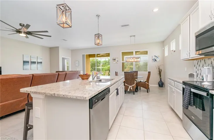Kitchen with appliances with stainless steel finishes, white cabinetry, ceiling fan, pendant lighting, and recessed lighting