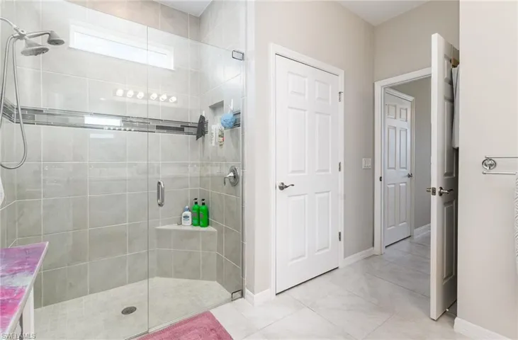 Full bath featuring a stall shower and light tile patterned flooring