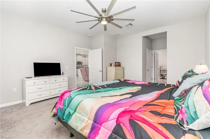 Carpeted bedroom featuring a ceiling fan and baseboards