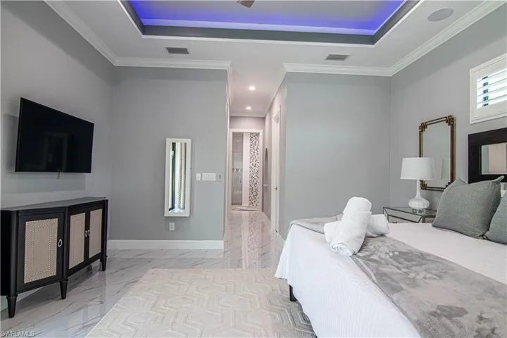 Bedroom with a tray ceiling and ornamental molding