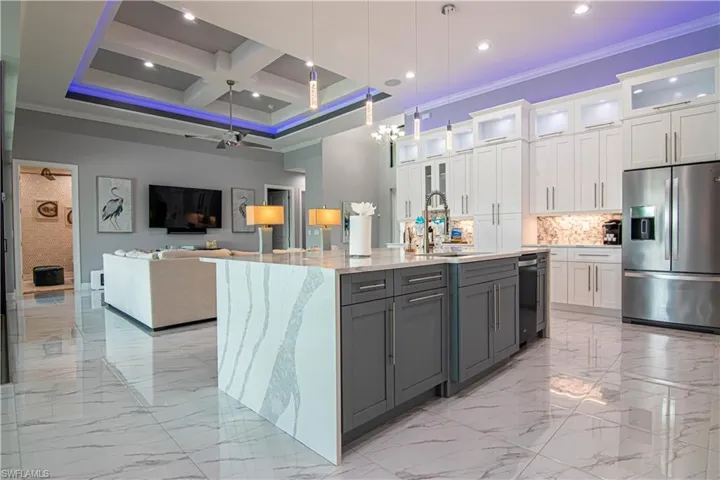 Kitchen with white cabinetry, appliances with stainless steel finishes, gray cabinetry, and coffered ceiling