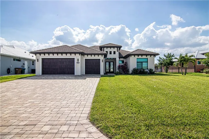 View of front of property with a front lawn and a garage