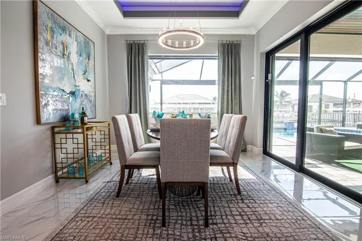 Dining area featuring an inviting chandelier, crown molding, and a tray ceiling