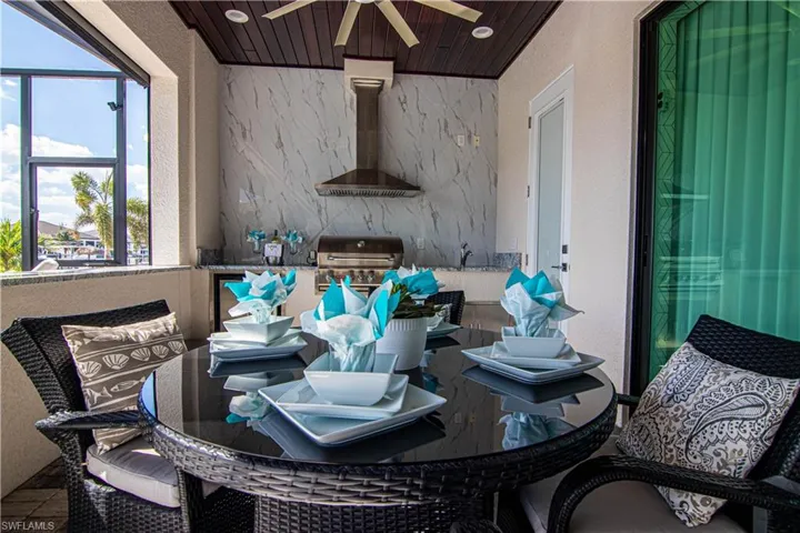 View of patio with area for grilling and a balcony