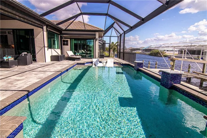 View of pool with a lanai, a dock, a water view, and a patio