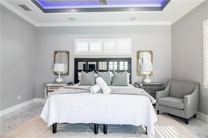 Bedroom with ornamental molding and a tray ceiling