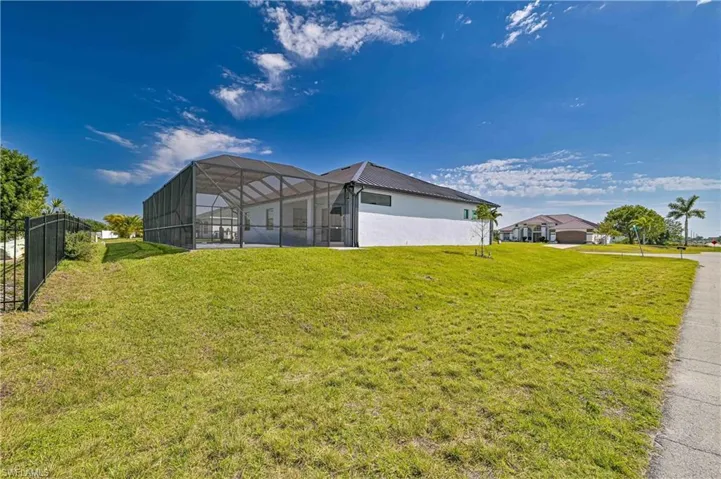 View of yard with fence and glass enclosure