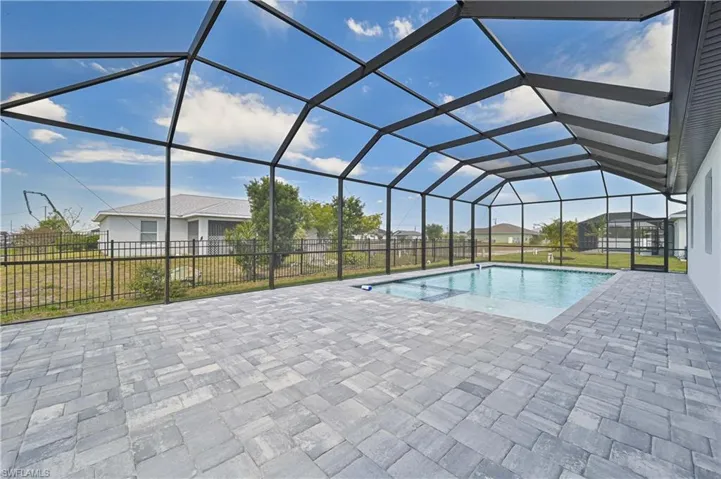 View of pool with a patio, a pool with connected hot tub, a lanai, and fence
