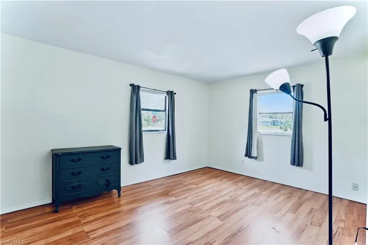 Unfurnished bedroom with light wood-style floors and baseboards