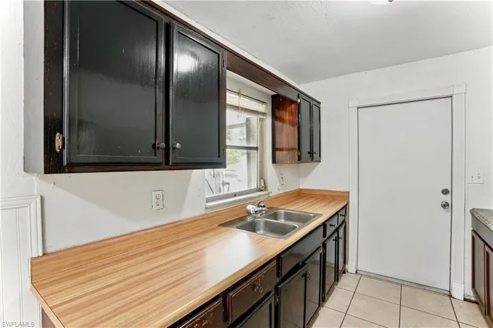 Kitchen featuring a sink, light tile patterned floors, and light countertops