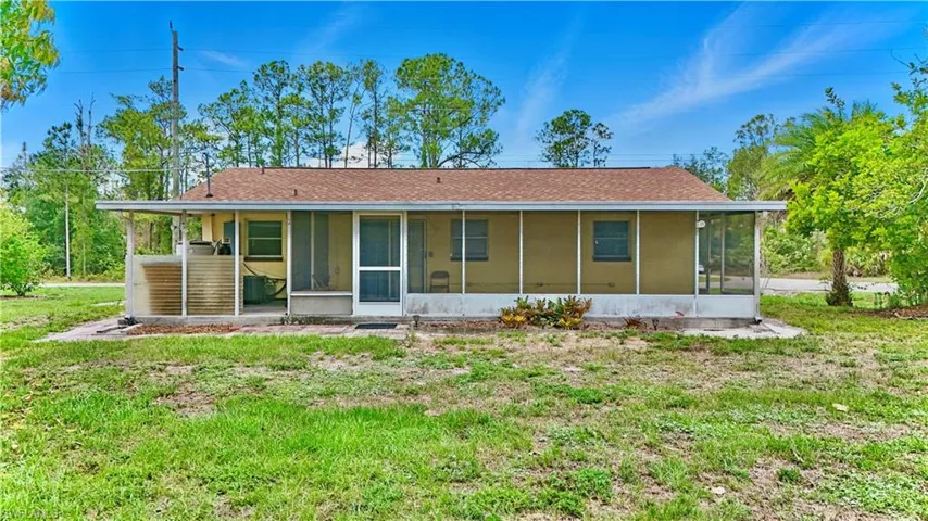 View of front of house featuring a sunroom and a front lawn