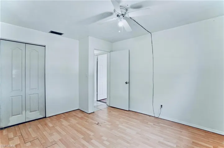 Unfurnished bedroom with wood finished floors, baseboards, and ceiling fan