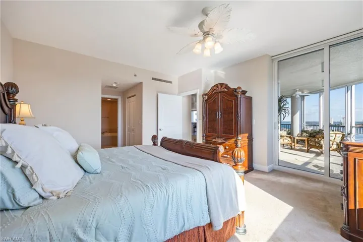 Carpeted bedroom with access to exterior, a ceiling fan, and connected bathroom