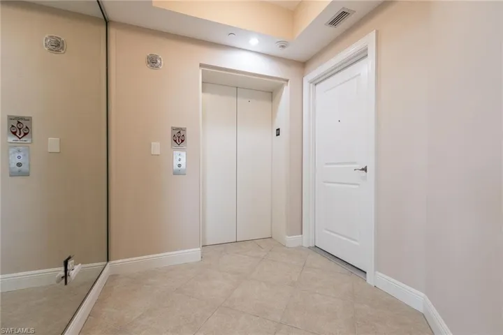 Hall with light tile patterned flooring and elevator